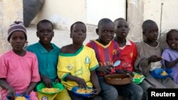 FILE - Children displaced as a result of Boko Haram attacks in the northeast region of Nigeria, eat at a camp for internally displaced persons (IDP) in Yola, Adamawa State, Jan. 13, 2015. 