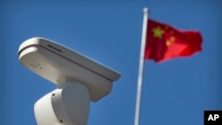 北京的一處海康威視監視攝像頭旁飄揚的中國國旗。 （2019年10月8日） 
