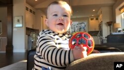 Archivo - Mason Camas, sonríe a su madre, Jocelyn Smith, quien cuida a su hijo de 11 meses en su casa en Camas, Washington, el 30 de enero de 2019, ante el temor del brote de sarampión en el suroeste del estado.