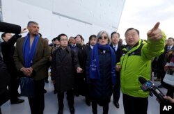 U.S. Gen. Vincent Brooks, left, commander of Combined Forces Command, South Korean Foreign Minister Kang Kyung-wha, third from right, and Natsuo Yamaguchi, second from right, head of the Komeito party that forms a governing coalition with Japanese Prime Minister Shinzo Abe's Liberal Democratic Party, are briefed by Lee Hee-beom, right, president of the Pyeongchang Organizing Committee for the 2018 Olympic and Paralympic Winter Games at the Gangneung Olympic Park in Gangneung, South Korea, Saturday, Nov. 25, 2017.