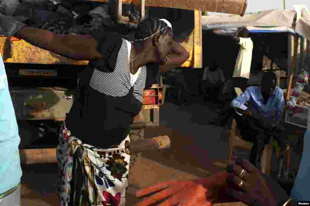 South Sudanese women, displaced by the fighting, collect garbage in a camp for displaced persons in the United Nations Mission in South Sudan (UNMISS) compound in Juba, February 19, 2014.