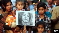 An Indian child poses with a placard as demonstrators participate in a protest in Allahabad, April 23, 2013, following the rape of a five-year old girl in New Delhi.