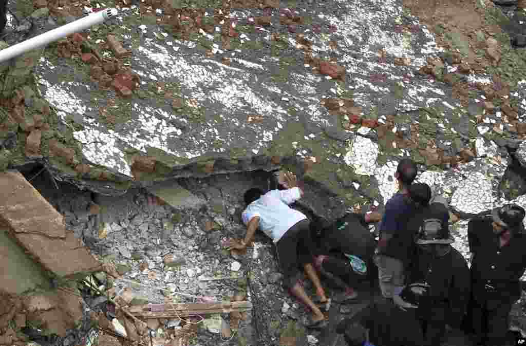 Para petugas penyelamat mencari para penyintas di lokasi gedung apartemen yang ambruk di Mumbai (27/9). 