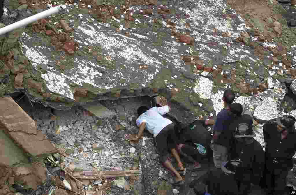Fire officials look for survivors from the debris of a collapsed building in Mumbai, Sept. 27, 2013.