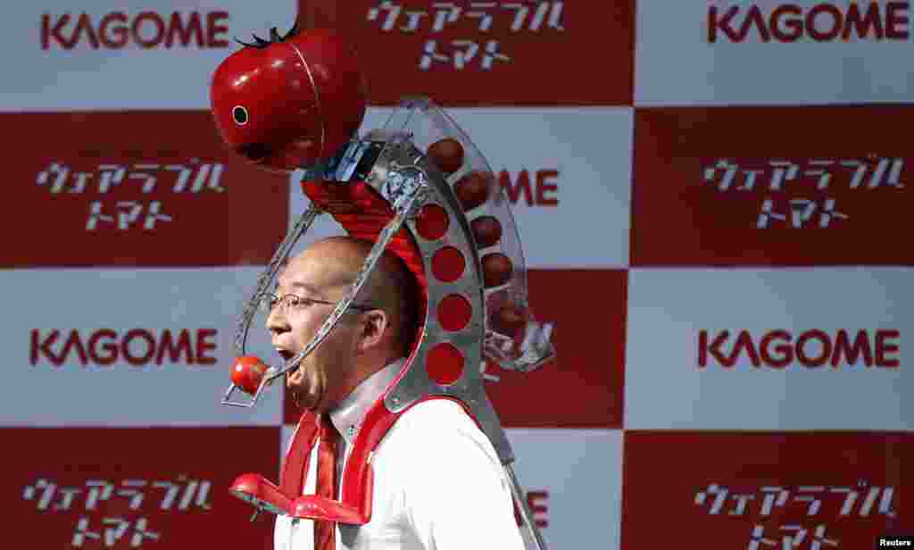 Kagome Co&#39;s employee Shigenori Suzuki tries to eat a tomato which is fed to him by the newly-developed &quot;Wearable Tomato&quot; device for runners, during its unveiling event ahead of the weekend&#39;s Tokyo Marathon in Tokyo, Japan.