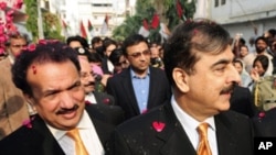 Pakistan's Prime Minister Yousuf Raza Gilani (R) and Interior minister Rehman Malik (L) arrive at the Muttahida Qaumi Movement (MQM) headquarters in Karachi, Jan 7, 2011.