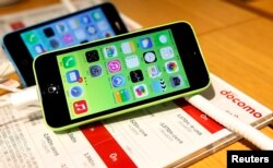 FILE - These then-new Apple iPhone 5c models were on display in at Tokyo store, Sept. 20, 2013. A 5c is at the center of Apple's battle with the FBI over efforts to break the company's proprietary auto-destruct security system.
