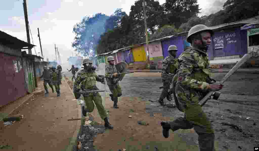 La police anti-émeute chasse des manifestants qui ont lancé des pierres, dans le bidonville de Kibera, à Nairobi, 23 mai 2016.