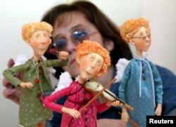 Seorang karyawan galeri mengatur komposisi boneka "Angels" dalam persiapan pameran boneka tangan di Moskow, 10 Desember 2003. (Foto: REUTERS). Pameran ini kembali digelar di Moskow tahun ini.