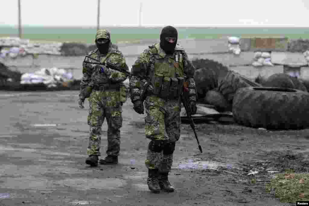 Homens armados pró-russos de guarda num posto de controlo depois de activistas pró-russos incendiarem pneus quando soldados ucranianos chegaram em carros blindados, nos arredores de&nbsp;Slovyansk, Abril 30, 2014.