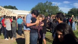 FILE: In this image made from a video by KWES-TV, people gather near the Alpine High School school campus after a shooting, in Alpine, Texas, Thursday, Sept. 8, 2016.