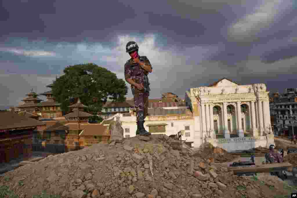 A Nepalese policeman stands atop of a rubble at Basantapur Durbar Square that was damaged in Saturday’s earthquake in Kathmandu, Nepal.