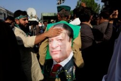 Seorang pendukung mantan Perdana Menteri Nawaz Sharif menyentuh fotonya saat dia merayakan dengan orang lain menyusul keputusan pengadilan di Islamabad, Pakistan 19 September 2018. (Foto: dok).