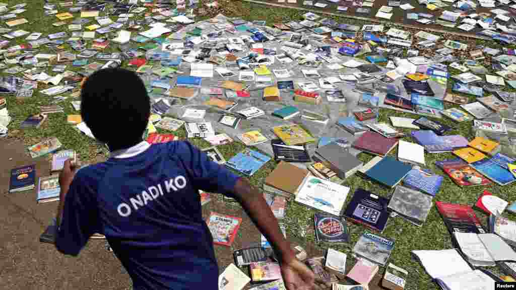 Un garçon court et dépasse des livres et autres documents exposés pour sécher au soleil après que le plafond d&#39;une librairie centrale a été souflé emporté par le cyclone Pam à Port Vila, la capitale de l&#39;état insulaire de Vanuatu, dans le Pacifique, le 18 mars 2015.