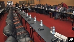 Congolese delegation sits opposite row of empty seats intended for delegation of M23 rebels, Kampala, Uganda, Dec. 10, 2012.