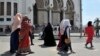Des femmes en voile se promènent devant une mosquée à Alger, 10 août 2016.