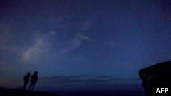 A couple enjoys the Perseid meteor along the Milky Way illuminating the dark sky, Aug. 12, 2017, near Comillas, Cantabria community, northern Spain, during the Perseids meteor shower. 