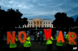 Protesters hold signs spelling out, "No War," outside the White House, Thursday June 20, 2019, in Washington, after President Donald Trump tweeted that "Iran made a very big mistake" by shooting down a U.S. drone.