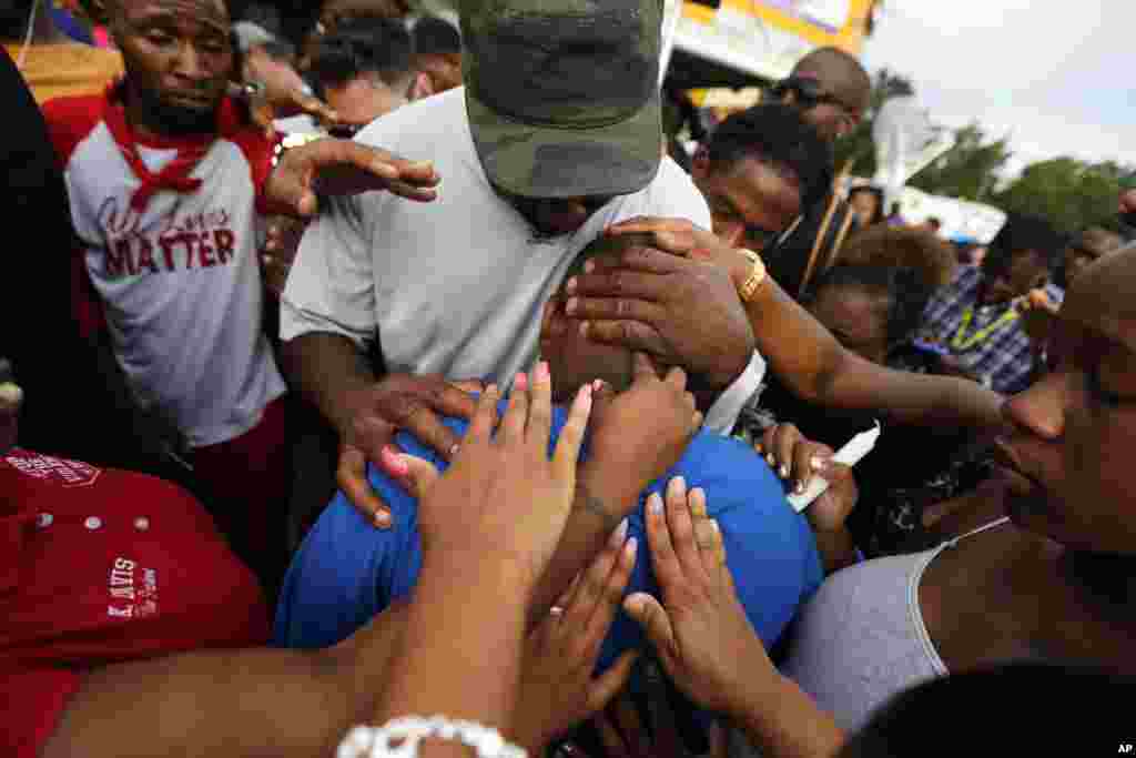 Le fils de Alton Sterling, Cameron Sterling,&nbsp;est réconforté par la foule à Baton Rouge, le 6 juillet 2016.