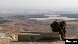 FILE - An Israeli soldier rests after completing a 45 kilomter march in the Jordan Valley, Jan. 2, 2014. The Jordan Valley is part of the West Bank and borders Jordan. 