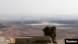 Seorang serdadu Israel beristirahat setelah berjalan sejauh 45 km dekat pemukiman Yahudi, Tomer, di Lembah Yordan dalam foto yang diambil tanggal 2 Januari 2014. (foto: REUTERS/Ronen Zvulun)