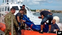 The body of a drowned migrant is being unloaded from a Coast Guard boat in the port of Lampedusa, Italy, Oct. 3, 2013. 