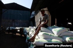 Seorang pekerja duduk di atas karung gula di dekat gudang pabrik gula Tasik Madu di Solo, Jawa Tengah, 4 Agustus 2011. (Foto: REUTERS/Beawiharta)