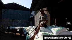 Seorang pekerja duduk di atas karung gula di dekat gudang pabrik gula Tasik Madu di Solo, Jawa Tengah, 4 Agustus 2011. (Foto: REUTERS/Beawiharta)