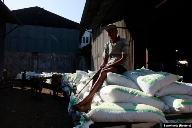 Seorang pekerja duduk di atas karung gula di dekat gudang pabrik gula Tasik Madu di Solo, Jawa Tengah, 4 Agustus 2011. (Foto: REUTERS/Beawiharta)
