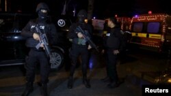 Tunisian police officers stand guard after an attack on a military bus Nov. 24, 2015, in Tunis, Tunisia. 