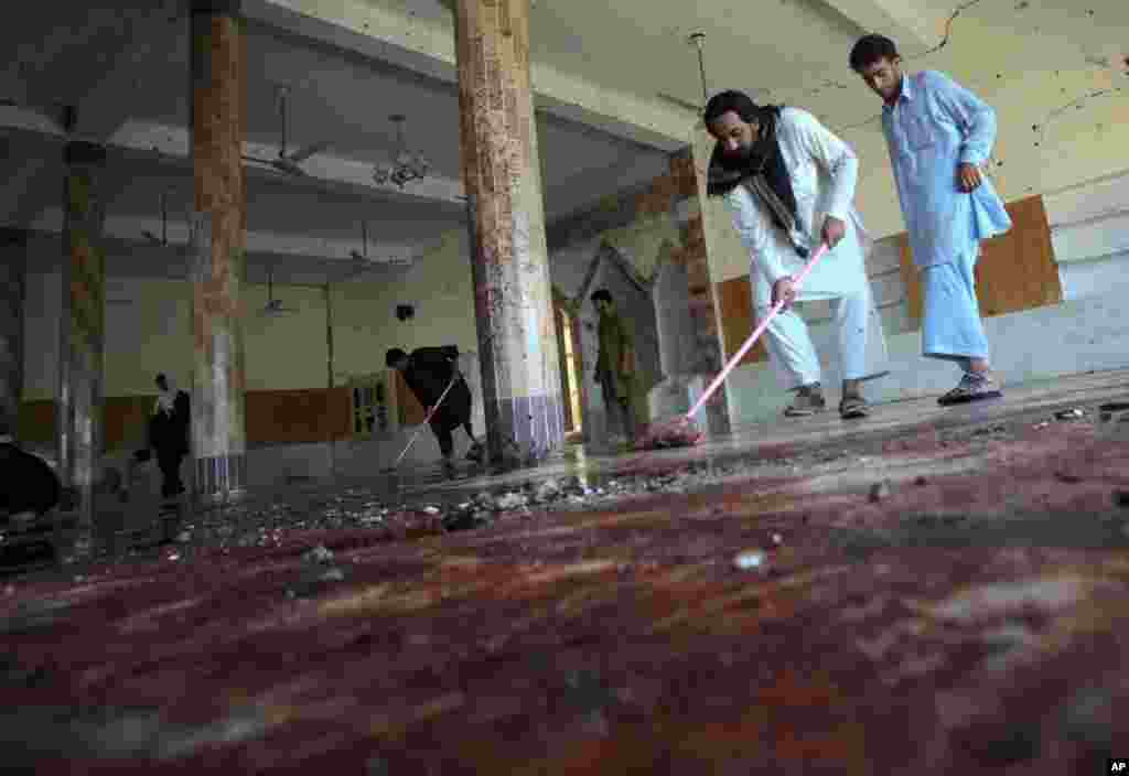 Men clean blood off the marble floors of Madina mosque after it was hit by a suicide bomb blast in Jamrud, located in Pakistan's Khyber region August 19, 2011. A suspected suicide bomber killed at least 34 people in a mosque during Friday prayers in Pakis