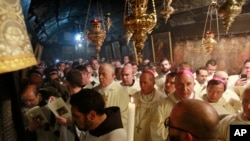 Latin clergies gather in the Grotto at the end of the midnight mass in Saint Catherine's Church where Christians believe the Virgin Mary gave birth to Jesus Christ, in the adjacent Church of the Nativity in Bethlehem, Dec. 25, 2016.