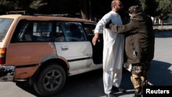 Arhiva - Talibanski borac pretresa čovjeka na kontrolnom punktu u Kabulu, Afganistan, 5. novembra 2021.