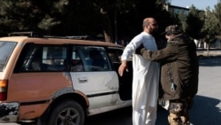 FILE - A Taliban fighter searches a man at a checkpoint in Kabul, Afghanistan November 5, 2021.