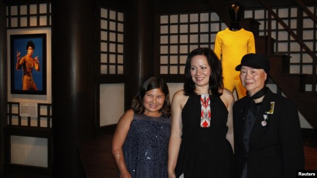 资料照：已故功夫巨星李小龙的女儿李香凝(中)与家人在香港文化博物馆李小龙展厅内拍照留念。 （2013年7月19日）