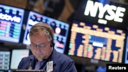 Seorang pekerja tengah mengamati perkembangan saham di lantai bursa New York (NYSE), 15 February 2013. (REUTERS/Brendan McDermid).