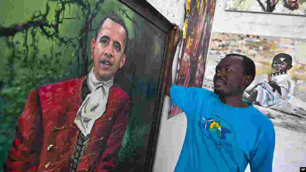 Le peintre kenyan Evans Yegon, connu sous le nom &quot; Yegonizer &quot;, pose à cots de deux tableaux du président americain, le 22 juillet 2015.