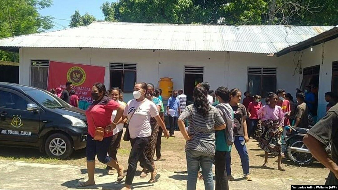 Para penduduk desa tampak berhamburan keluar dari salah satu bangunan di Maumere, Nusa Tenggara Timur, setelah gempa sebesar 7,4 magnitudo melanda wilayah Flores, pada 14 Desember 2021. (Foto: AFP/Yanuarius Arlino Welianto)