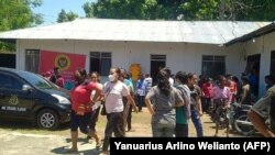 Para penduduk desa tampak berhamburan keluar dari salah satu bangunan di Maumere, Nusa Tenggara Timur, setelah gempa sebesar 7,4 magnitudo melanda wilayah Flores, pada 14 Desember 2021. (Foto: AFP/Yanuarius Arlino Welianto)