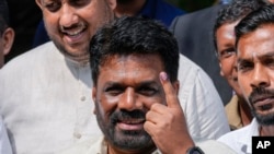 Sri Lankan President Anura Kumara Dissanayake shows his finger as he leaves after casting his vote during the parliamentary election in Colombo, Sri Lanka, Nov. 14, 2024.