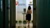 FILE - A woman enters an office in Beijing, China.