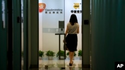 A woman enters an office of GlaxoSimthKline in Beijing, China, July 11, 2013. 