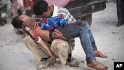 FILE - In this Oct. 3, 2012 file photo, a man cries while holding the body of his son, killed by the Syrian Army, near Dar El Shifa hospital in Aleppo, Syria. 