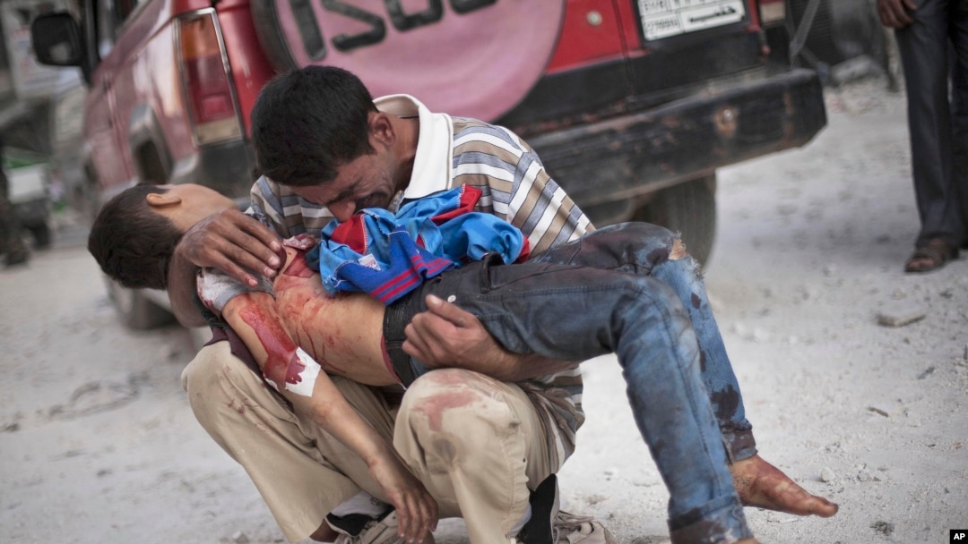 Foto bertanggal 3 Oktober 2012 ini menunjukkan seorang pria menangis sambil menggendong anak laki-lakinya yang tewas di tangan Tentara Suriah dekat rumah sakit Dar El Shifa di Aleppo, Suriah.