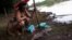 An Indigenous woman from the Pataxo Ha-ha-hae tribe looks at dead fish near Paraopeba river, after a tailings dam owned by Brazilian mining company Vale SA collapsed, in Sao Joaquim de Bicas near Brumadinho, Brazil, Jan. 28, 2019. 