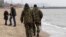 File - Local volunteers patrol the city beach in Mariupol, Donetsk region of Ukraine.