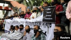 FILE - Journalists hold banners and placards as they protest laws they fear are aimed at curbing press freedom in Dhaka, Bangladesh, Oct. 11, 2018. On Monday, Bangladesh shut down dozens of online news portals for several hours.