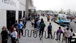 Job candidates wait in lines outside the recruitment office at the Amazon fulfillment center in Robbinsville, N.J., during a job fair, Aug. 2, 2017