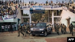 FILE - A vehicle carrying the president of the Central African Republic, Faustin-Archange Touadera, arrives at a stadium for an election rally, in Bangui, Dec. 19, 2020.