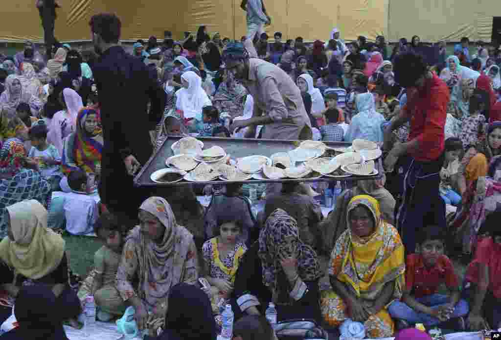 لاہور میں رضاکار سڑک کنارے لگائے گئے ایک کیمپ میں روزہ داروں میں کھانے پینے کی اشیا تقسیم کر رہے ہیں۔